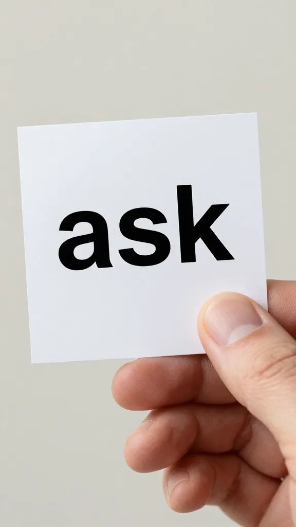 Closeup of a hand holding a single “ask” note in soft lighting