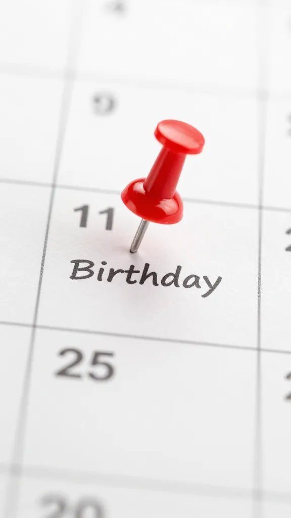 closeup of a calendar page marking a birthday with a single pin