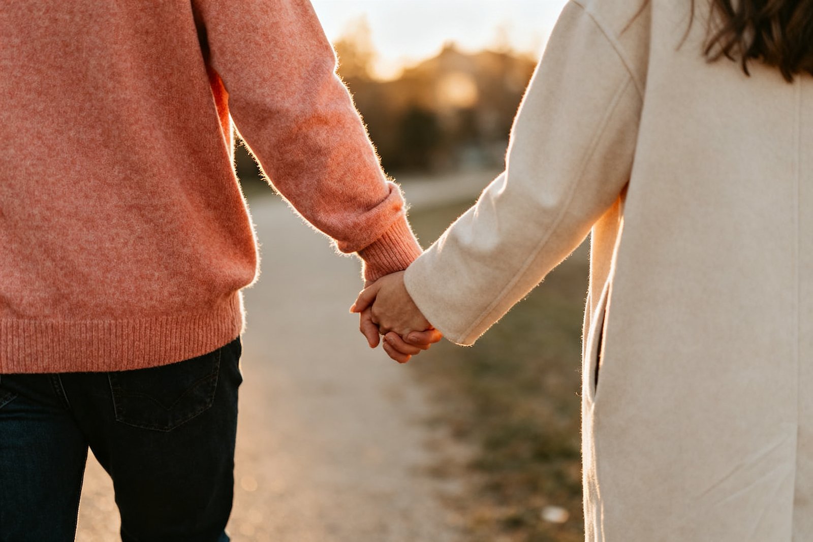 A couple walking together outdoors holding hands