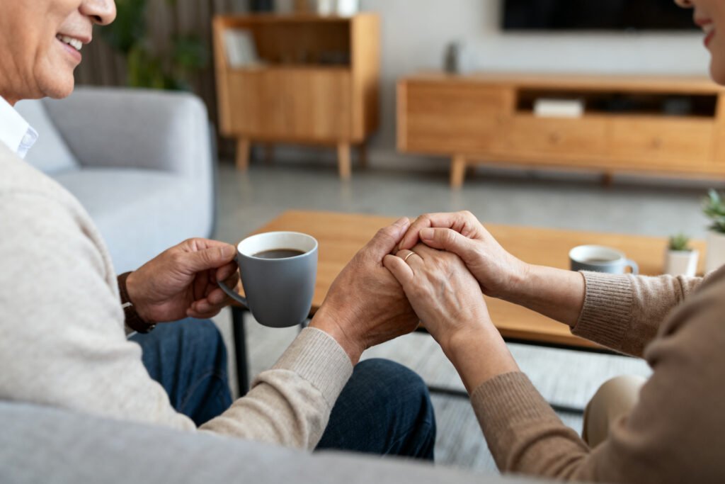 Parents holding hands over coffee
