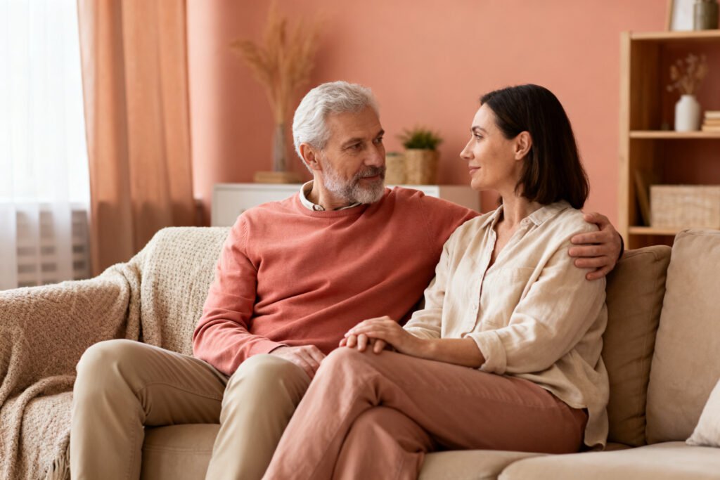 A couple having a calm, supportive conversation on the sofa at home