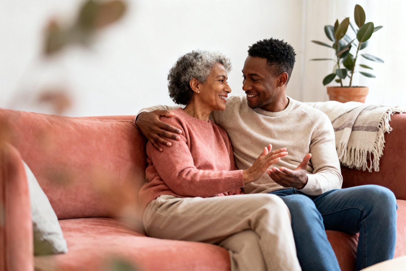 Two people talking gently on the couch, reflective
