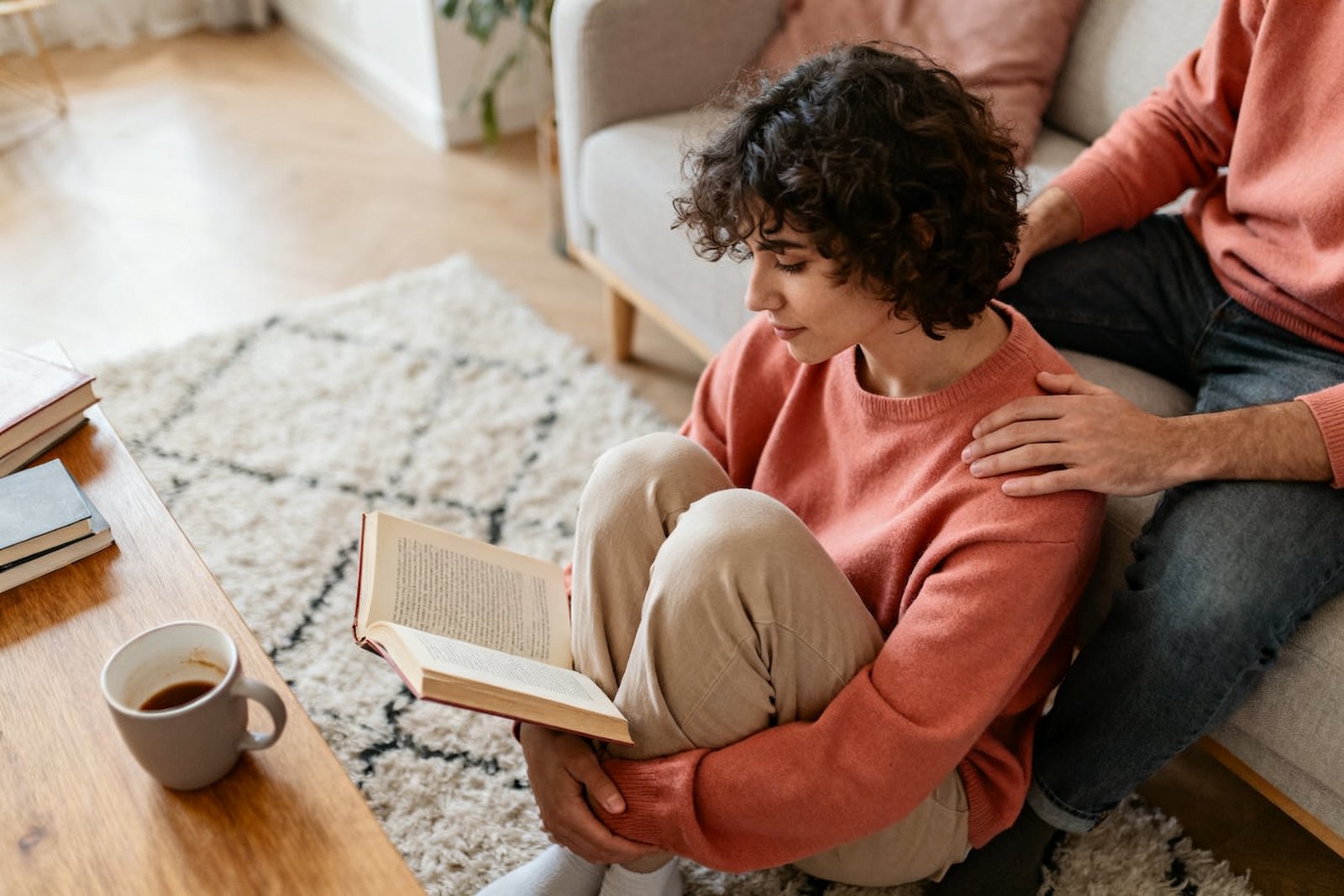A person enjoying quiet time with a book while their partner sits nearby, cozy