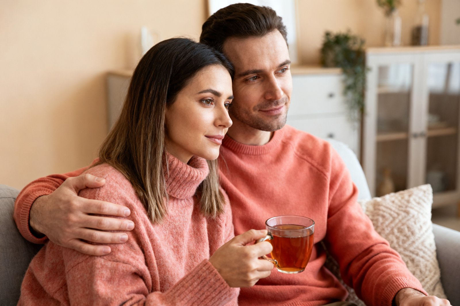 A couple taking a calm pause together, one holding a warm mug of tea