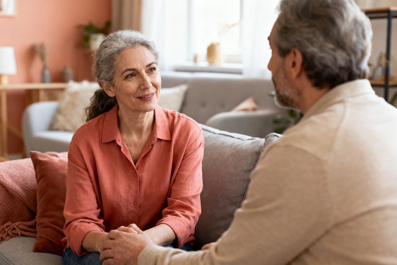 One partner listening patiently and warmly while the other speaks, cozy living room