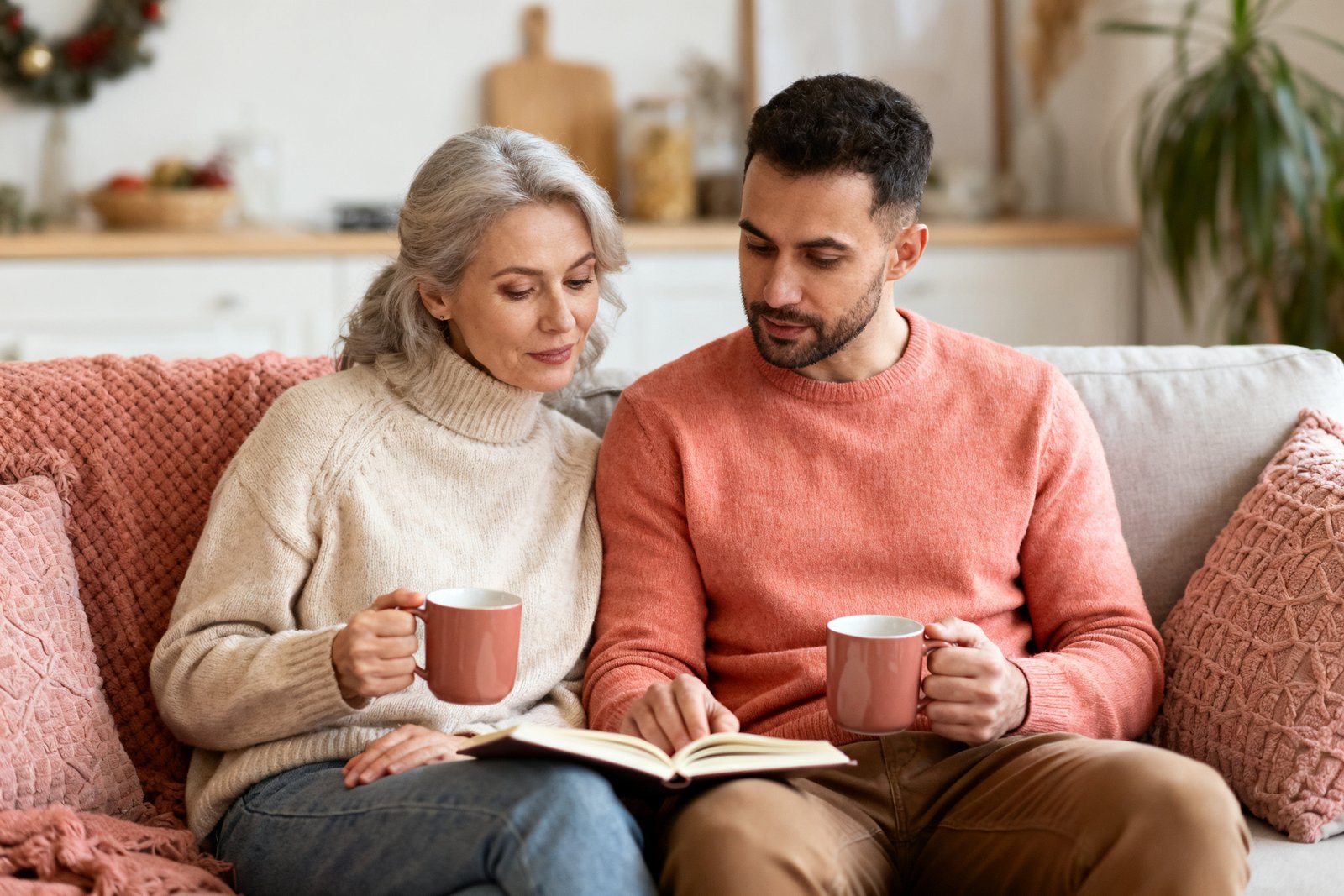 A couple reflecting together with a notebook and warm drinks, cozy end-of-year mood