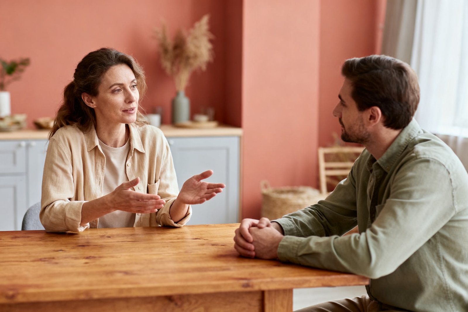 A couple having a calm, understanding conversation about balance and plans at a table