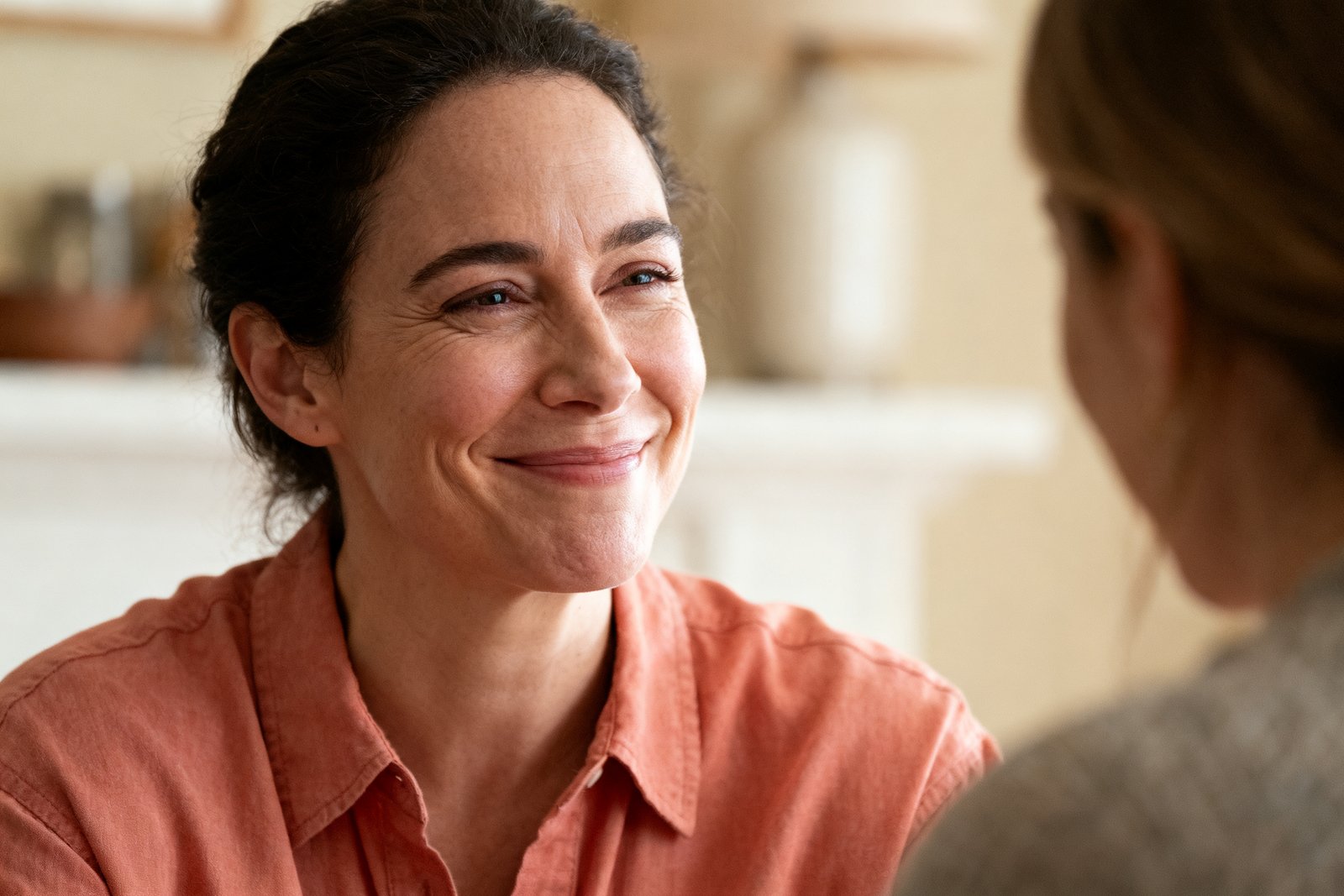 A close portrait of a person nodding warmly while listening