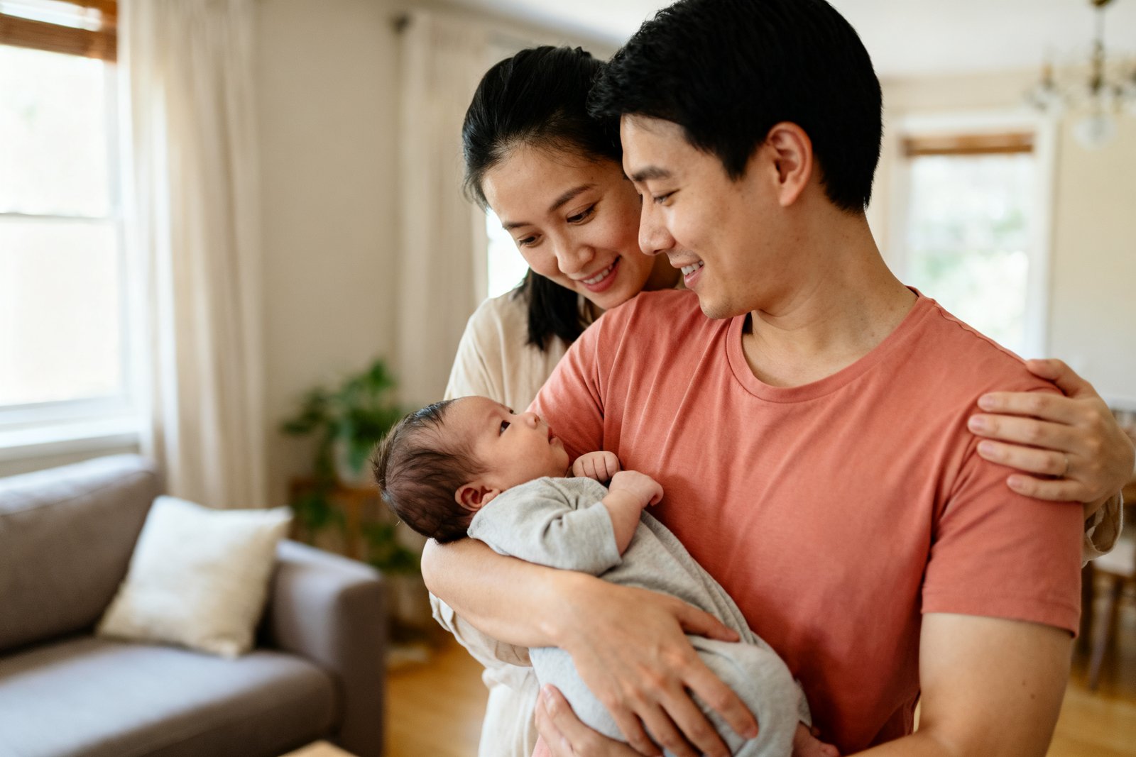 New parents sharing a tender, supportive moment together at home, gentle and warm